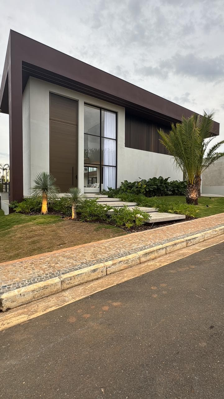 Fachada de residência contemporânea de alto padrão ao entardecer, com iluminação quente e linhas arquitetônicas limpas